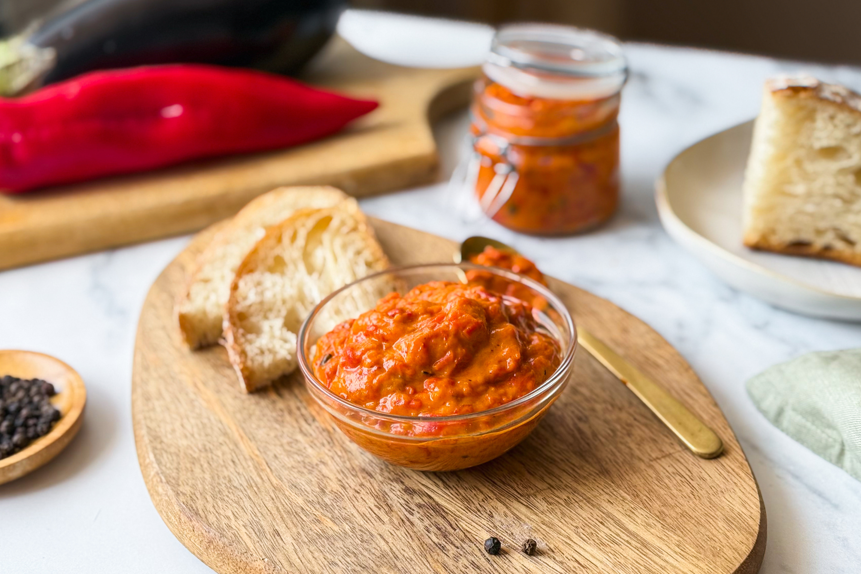 Hausgemachter Ajvar, serviert mit Brot.